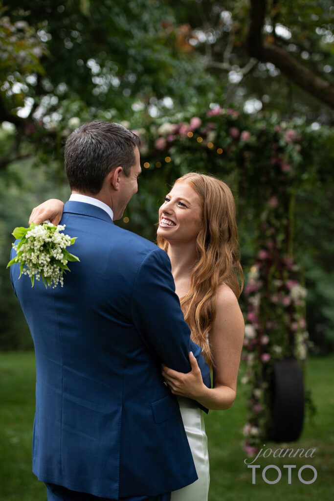 Bride and groom at an outdoor wedding at a private residence in Briarcliff Manor, NY in New York, with flowers by Bedford Village Flower Shoppe