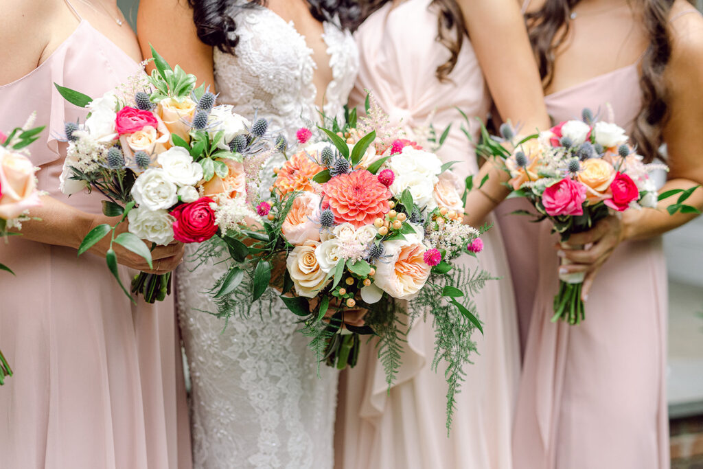 Bride and bridesmaids holding bouquets by Bedford Village Flower Shoppe